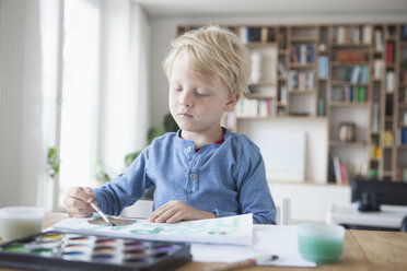 Porträt eines kleinen blonden Jungen, der mit Aquarellfarben malt - RBF004250