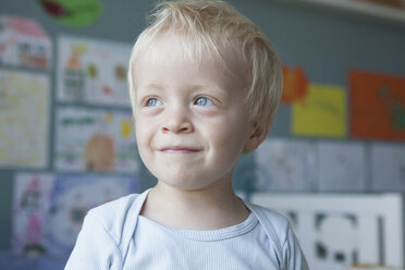 Porträt eines lächelnden kleinen blonden Jungen zu Hause - RBF004253