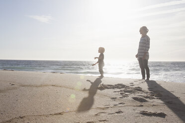 Mutter steht mit ihrem kleinen Sohn am Strand - RBF004260