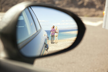 Spanien, Fuerteventura, Jandia, Spiegelung einer Familie an der Küste im Außenspiegel eines Autos - MFRF000591