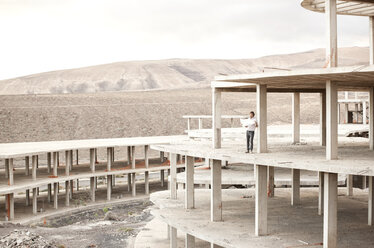 Spanien, Fuerteventura, Jandia, Architekt im Rohbau stehend - MFRF000614