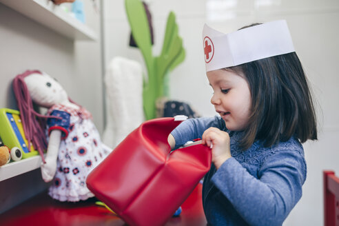 Kleines Mädchen sucht medizinisches Spielzeug in einer roten Tasche - DAPF000080