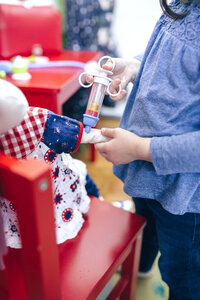 Kleines Mädchen gibt ihrer Puppe eine Spritze, Nahaufnahme - DAPF000082