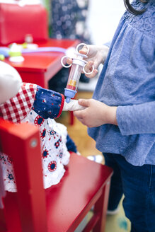 Kleines Mädchen gibt ihrer Puppe eine Spritze, Nahaufnahme - DAPF000082