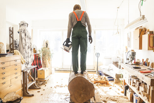 Holzschnitzer in der Werkstatt bei der Vorbereitung eines Baumstamms für eine Skulptur - TCF004942