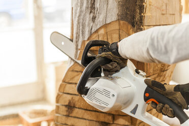 Holzschnitzer in der Werkstatt bei der Arbeit an einer Skulptur mit der Kettensäge - TCF004953