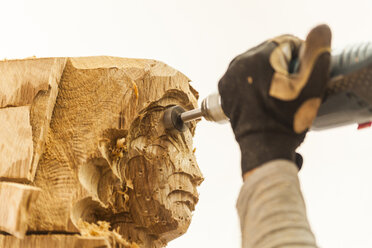 Holzschnitzer in der Werkstatt bei der Arbeit an einer Skulptur mit einer Fräsmaschine - TCF004957