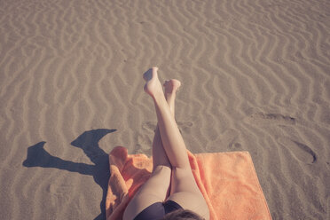 Beine einer Frau beim Entspannen am Strand - SIPF000321