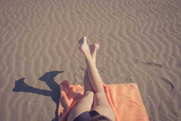 Legs of woman relaxing on the beach - SIPF000321