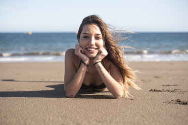 Spanien, Teneriffa, Porträt einer jungen Frau beim Entspannen am Strand - SIPF000324
