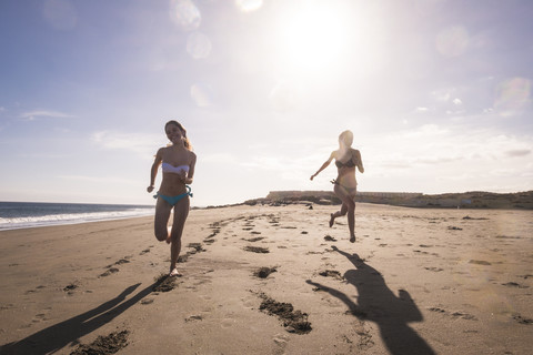 Spanien, Teneriffa, zwei Freundinnen laufen am Strand, lizenzfreies Stockfoto