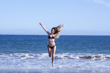 Spain, Tenerife, happy young woman at the sea - SIPF000343