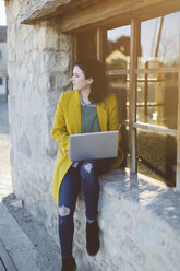 Frau benutzt Laptop vor einem Gebäude - JPF000123