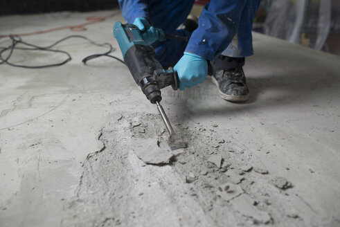 Arbeiter bearbeitet den Zementboden mit einem Presslufthammer - RAEF001026