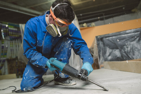 Worker treating the cement floor with a jackhammer - RAEF001033