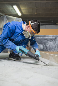 Worker treating the cement floor with a jackhammer - RAEF001034