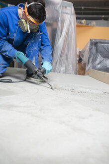 Worker treating the cement floor with a jackhammer - RAEF001035