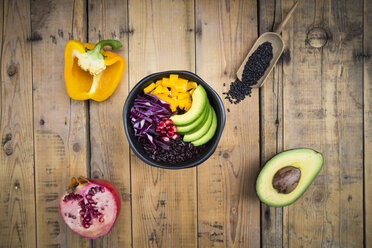 Lunch bowl with black rice, avocado, yellow bell pepper, red cabbage and pomegranate seed on wood - LVF004726