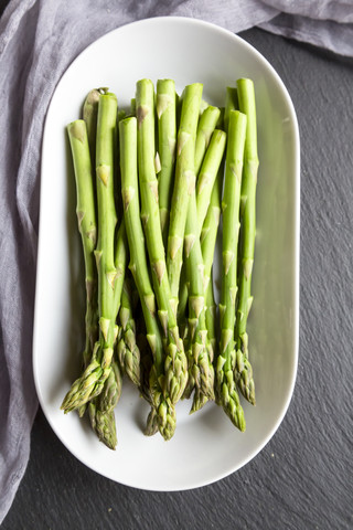 Platte mit grünem Mini-Bio-Spargel, lizenzfreies Stockfoto