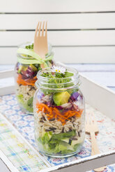 Springtime salad in glasses, lettuce hearts, radicchio, avocado, carrot, zucchini, wild rice and cress, daisy - LVF004734