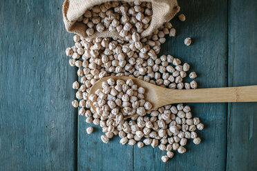 Dried chickpeas and wooden spoon on wood - KIJF000302