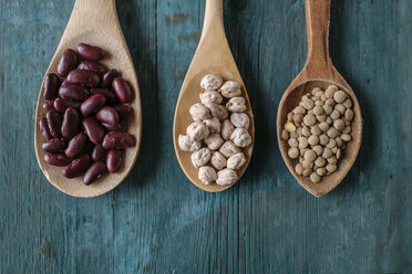 Row of three wooden spoons with dried brown lentils, red beans and chickpeas - KIJF000308