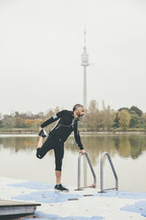 Österreich, Wien, Jogger bei Dehnungsübungen auf der Donauinsel - AIF000311