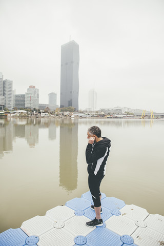 Austria, Vienna, jogger doing stretching exercise on Danube Island stock photo