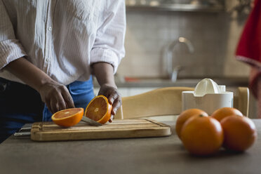 Young woman cutting oranges, partial view - MAUF000416