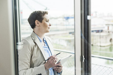 Geschäftsfrau mit digitalem Tablet am Fenster - UUF006775