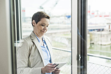 Geschäftsfrau mit digitalem Tablet am Fenster - UUF006776