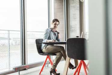 Businesswoman working at table in conference room - UUF006800