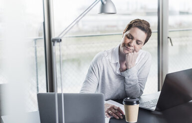 Tired businesswoman at desk - UUF006848