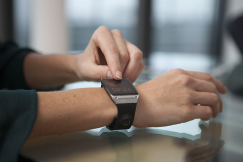 Smart watch on arm of mid adult woman stock photo