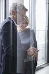 Geschäftsmann und Frau bei einer Besprechung, Blick auf ein digitales Tablet - RBF004280