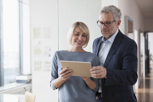 Geschäftsmann und Frau bei einer Besprechung, Blick auf ein digitales Tablet - RBF004374