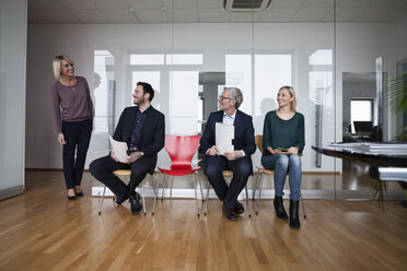 People sitting in a row, waiting in office - RBF004405