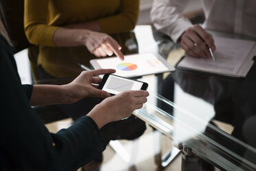 Business people at meeting in office using portabel devices - RBF004412