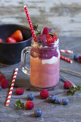 Smoothie with natural yoghurt, banana, strawberry, raspberry and blueberry in glass - YFF000534