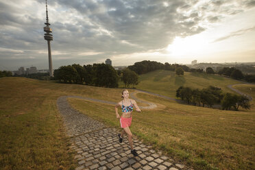 Deutschland, München, junge Frau beim Joggen am Morgen - FCF000915