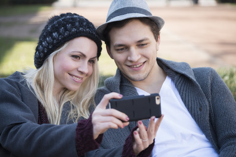 Porträt eines verliebten Paares, das ein Selfie mit einem Smartphone macht, lizenzfreies Stockfoto