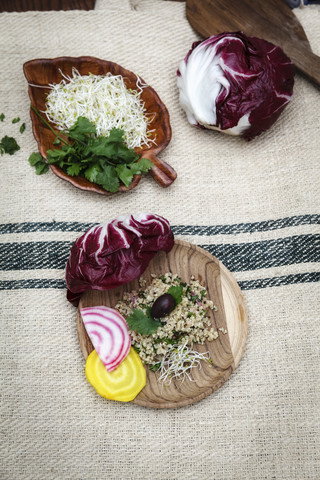 Quinoa-Salat, Radicchio, Rote Bete, gelb und rot auf Holzteller, lizenzfreies Stockfoto