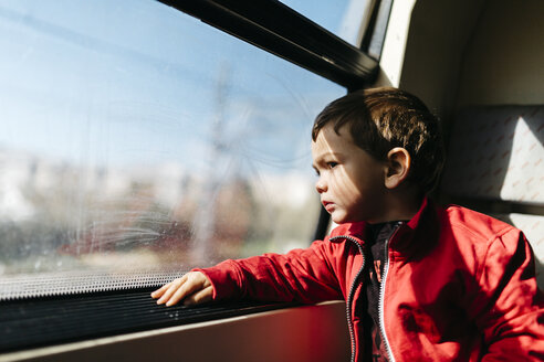 Kleiner Junge auf seiner ersten Zugfahrt mit Blick durch das Fenster - JRFF000533