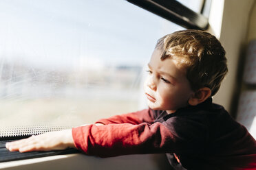 Porträt eines kleinen Jungen, der bei seiner ersten Zugfahrt durch das Fenster schaut - JRFF000537