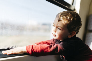 Portrait of little boy on his first train ride looking through window - JRFF000537