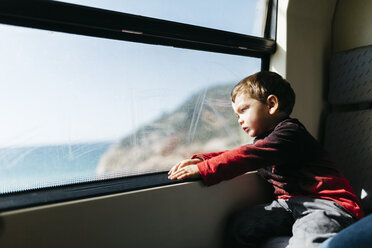 Little boy on his first train ride looking through the window - JRFF000538