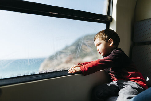 Kleiner Junge auf seiner ersten Zugfahrt mit Blick durch das Fenster - JRFF000538