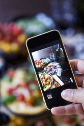 Woman taking a photo of dish with Italian food, close-up - VABF000430