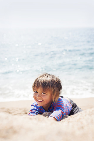 Porträt eines kleinen Jungen, der am Strand am Meer spielt, lizenzfreies Stockfoto