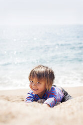 Portrait of little boy playing on the beach at seafront - VABF000436